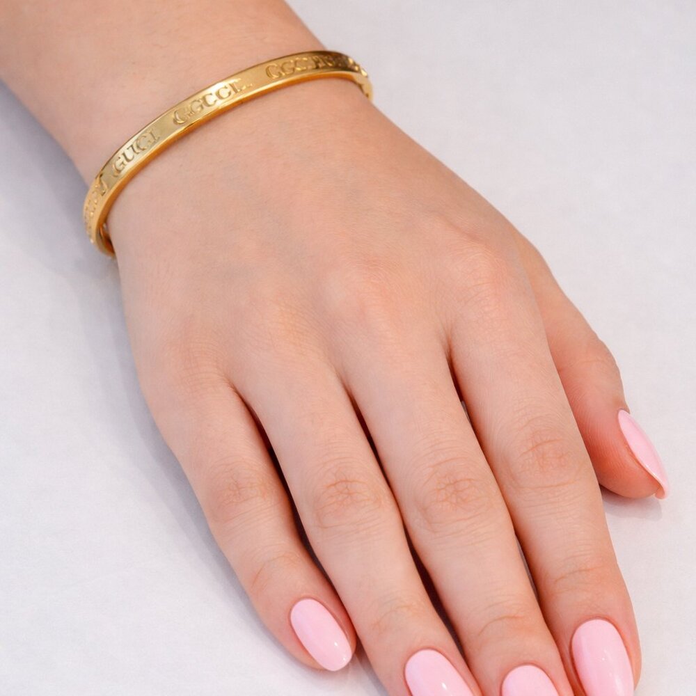 Gold colored monogramed bracelet that opens with pull. New without tags.